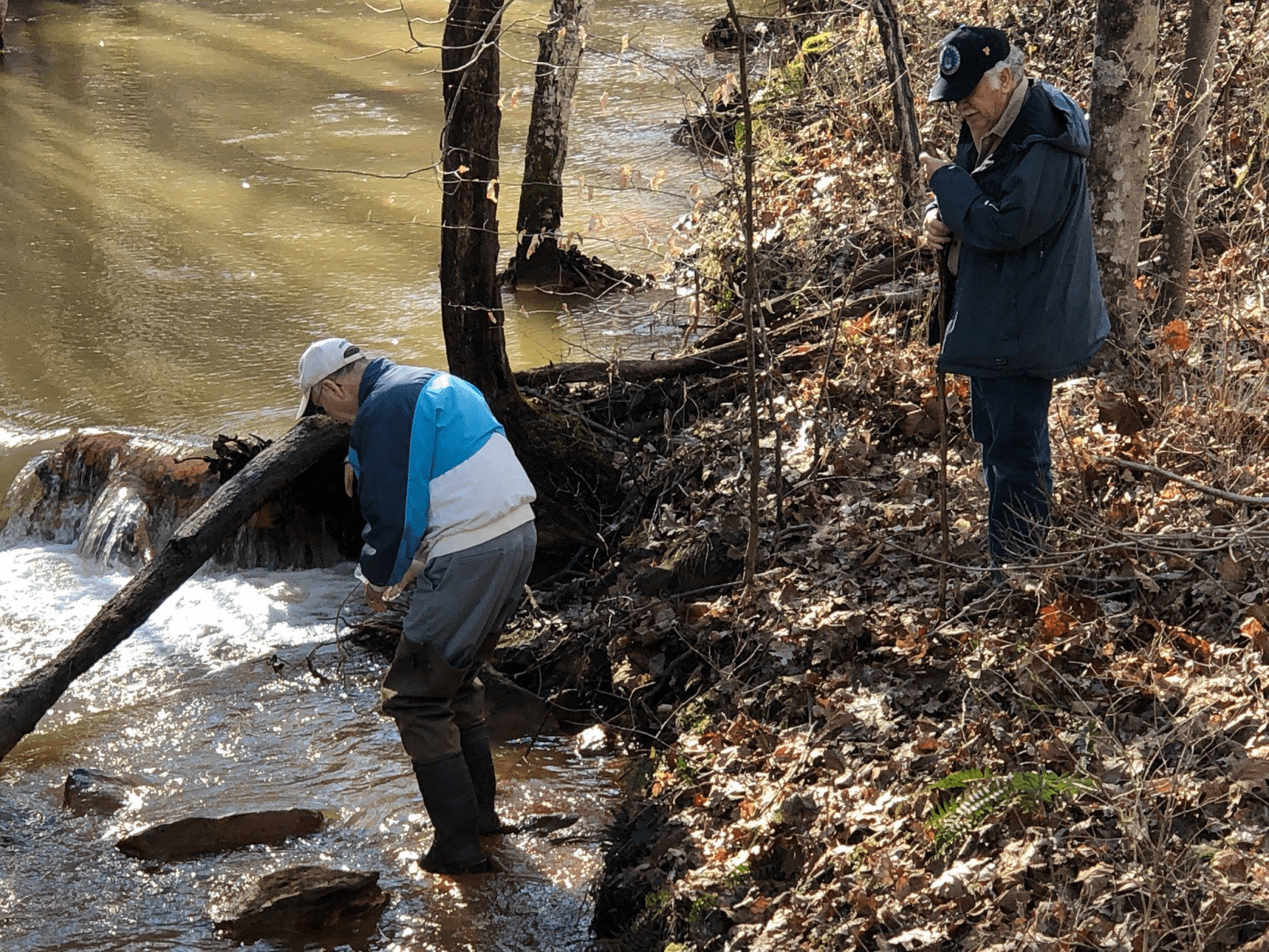 Two men testing river water on a fall day